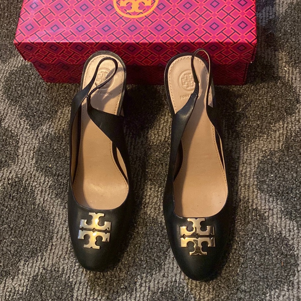 Tori Burch black stack heel sling back with emblem on the toe.